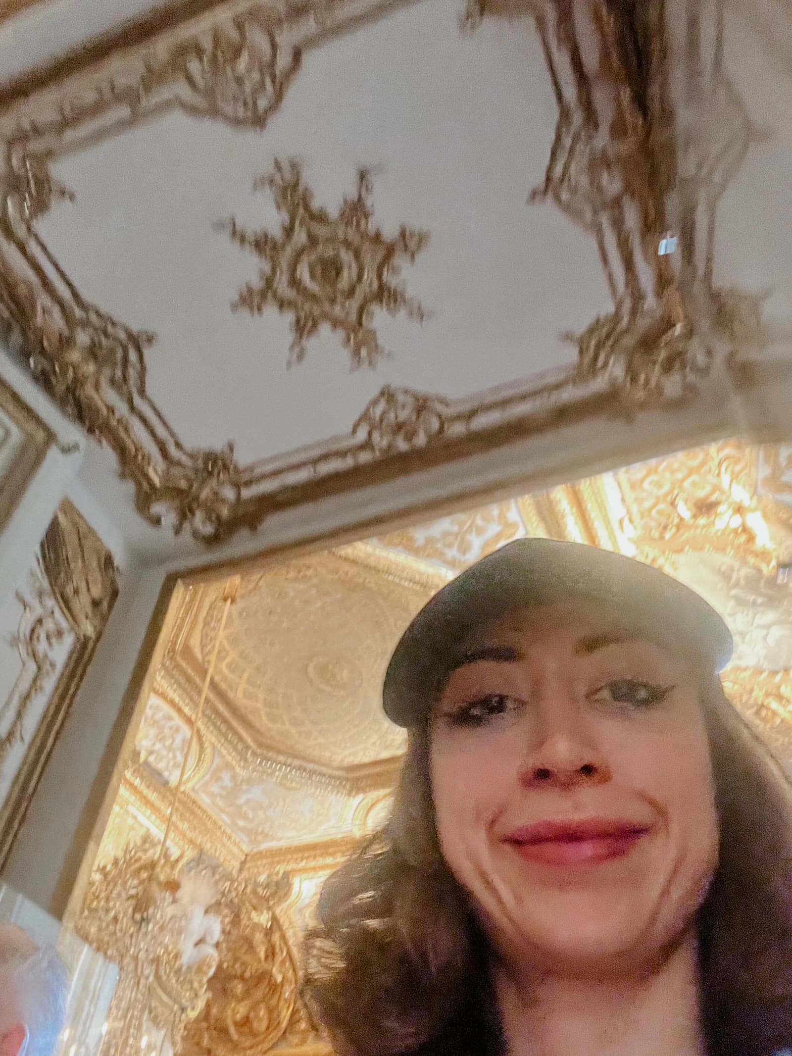 Sierra “Sisi” Moses wearing a hat in an ornate gilded room